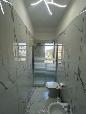 Hair dryer, towels, soap, shampoo - Industrial design apartment with modern minimalist interior (Napoli)