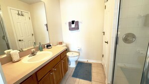 Un baño con lavamanos doble, inodoro y ducha.