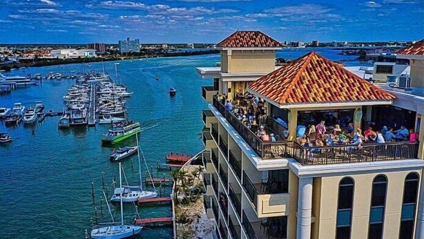 A waterfront property with a balcony overlooking a marina filled with boats.
