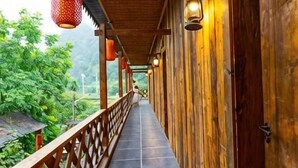 A wooden corridor with a tiled floor, wooden railings, and hanging lanterns. - Changyang farming, soil and flavor farm (Changyang)