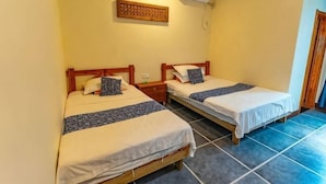 A hotel room with two single beds, a wooden headboard, a wall-mounted air conditioner, and a tiled floor. - Changyang farming, soil and flavor farm (Changyang)