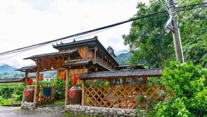 A traditional wooden structure with a lattice fence, stone steps, and a rustic setting. - Changyang farming, soil and flavor farm (Changyang)