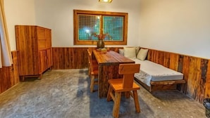 A room with a wooden dining table, chairs, a sofa, a window with a view, and a cabinet. - Changyang farming, soil and flavor farm (Changyang)