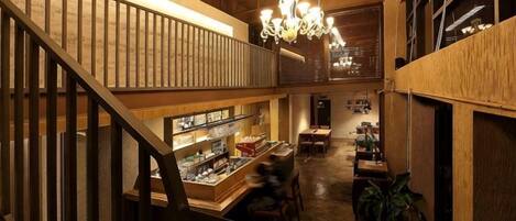 A wooden interior with a staircase, a bar area, and hanging lights.