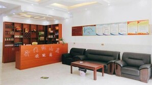 A reception area with a wooden desk, black leather sofas, a chandelier, and informational posters on the wall. - Jianshi Hongshan Villa (Jianshi)