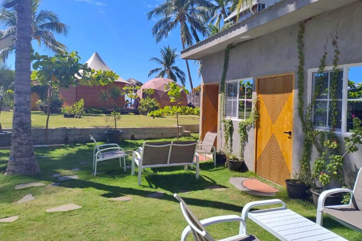 Um resort tropical com piscina, espreguiçadeiras e palmeiras.