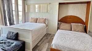 Une chambre avec deux lits, un canapé et une fenêtre avec des rideaux.