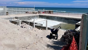 Un chantier de construction avec une piscine en béton, une brouette et du matériel de construction.