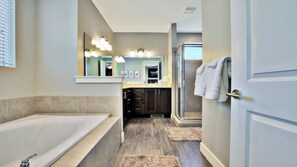 A modern bathroom with a bathtub, vanity, and a walk-in shower.