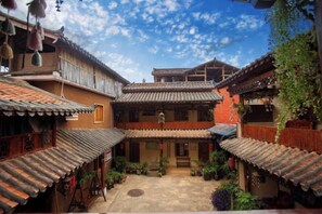 Ein Innenhof mit traditioneller Architektur, darunter Ziegeldächer und hölzerne Balkone.