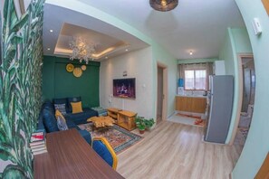Relax in this inviting space with a comfortable seating area, flat-screen TV, and dining table.