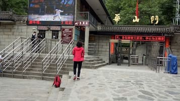 Una escalera de piedra conduce a un edificio donde se proyecta un evento deportivo en una pantalla grande.