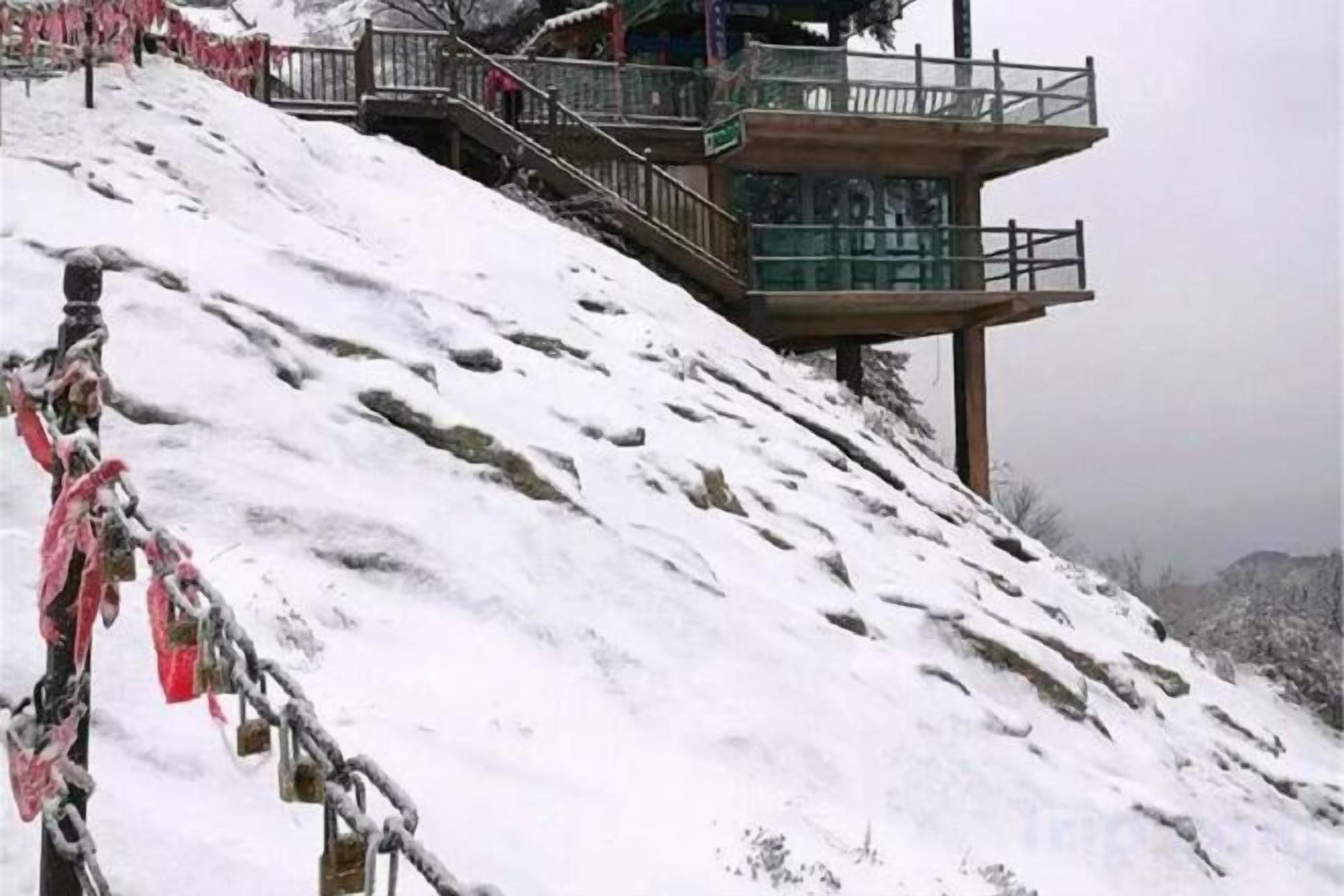 Pendiente nevada con una pasarela de madera y una escalera que sube.