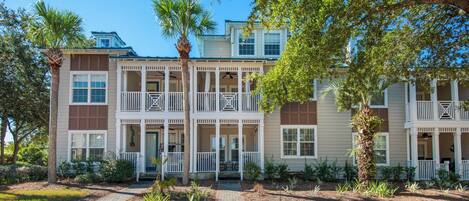 A multi-story residential building with a central courtyard, balconies, and a well-maintained garden.