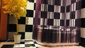 A checkered floor, a white vase with yellow flowers, and a purple curtain. - Guoran Theme Hotel (Wuhan Huquan) (Wuhan)