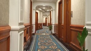 A hallway with wooden doors, white walls, and a patterned carpet. - Guoran Theme Hotel (Wuhan Huquan) (Wuhan)