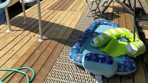 A wooden deck with lounge chairs, a covered area, and an inflatable pool. - Beautiful Waterfront Cottage with Hot Tub in South Muskoka  (Severn Bridge)