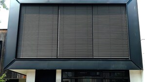 A modern building with a large overhang and horizontal slats. - Maison 50 m2, à 5 Minutes de Paris et Idéal Pour Disney (Montreuil)