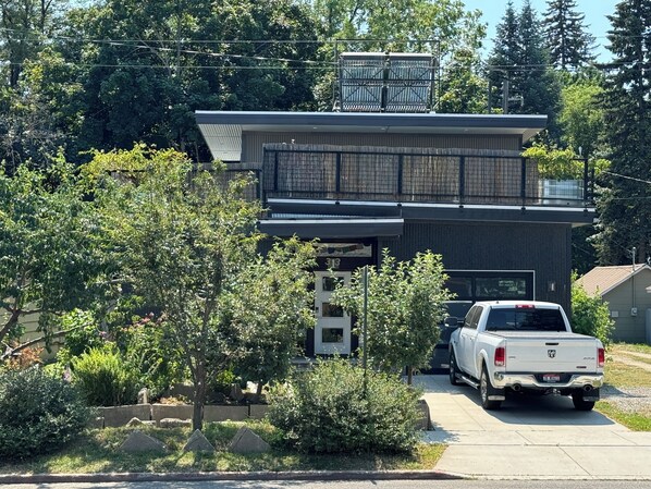 A modern two-story house with a garage and a white pickup truck parked in front.