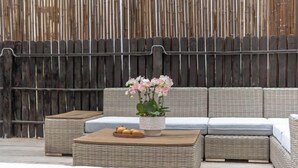 A wicker sofa set with a side table and a potted orchid. - Guiyu·Yin (Hangzhou)