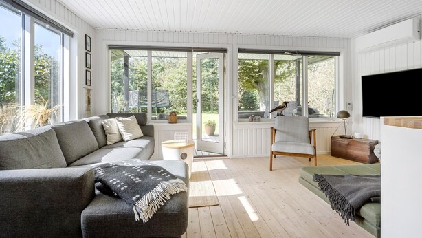 A spacious living room with a grey sofa, a green armchair, and a wooden coffee table. Large windows offer a view of the outdoors. - Pet friendly home in Spøttrup with WiFi (Spøttrup)