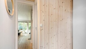 A wooden-paneled hallway leading to a room with a large window and a door with a light switch. - Pet friendly home in Spøttrup with WiFi (Spøttrup)