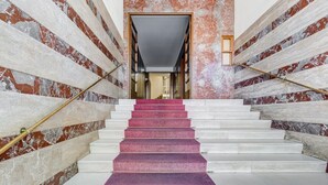 A marble staircase with a purple carpet, leading to a doorway. - L&L - Central charming 2-Bdr! (Roma)