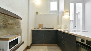 Una cocina compacta con microondas, lavabo y armarios.