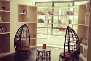 A reading area with two chairs and a table, surrounded by bookshelves.