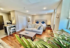 A modern living room with a sofa, coffee table, and a bed with a headboard. - 403 Luxury and Comfy King bed in Central city of philly

 (Philadelphia)