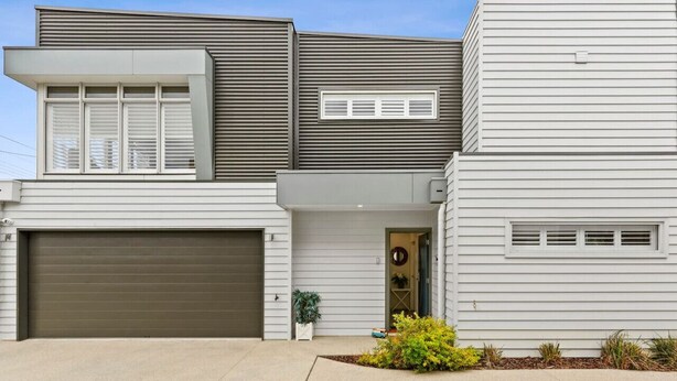 A modern two-story house with a garage, a front door with a wreath, and a small garden area. - Kismet- Family fav, 12pm check out, Parking, Walk to the beach (Ocean Grove)