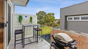 A balcony with a grill, two black bar stools, and a glass table. - Kismet- Family fav, 12pm check out, Parking, Walk to the beach (Ocean Grove)