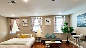 A modern bedroom with a bed, sofa, coffee table, and a small dining area with chairs. - 406 The easy stays in central city of Philadelphia (Philadelphia)