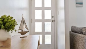 Ein Holztisch mit einem Segelbootsmodell, einer Topfpflanze und einer Tür mit einer Milchglasverglasung.