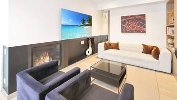 Een smart-tv, een open haard, boeken en een kantoor