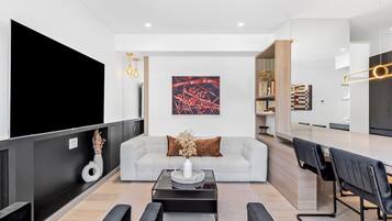 Een smart-tv, een open haard, boeken en een kantoor