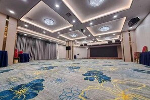 A hotel room with a large carpeted area, a flat-screen TV, and a curtain backdrop. - Vienna Hotel (Guangzhou Panyu Chimelong Dashi Jiangjing Garden Branch) (Guangzhou)