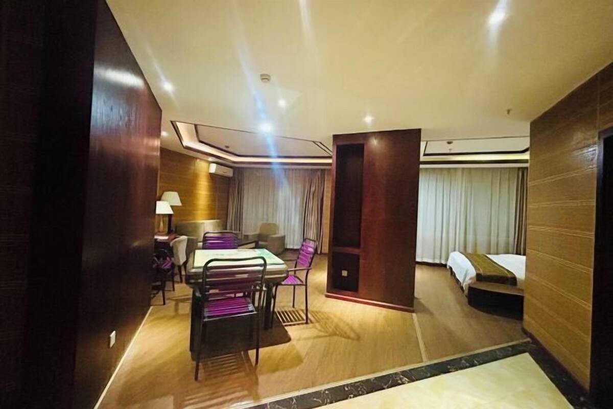 A hotel room with a dining area, a bed, and a bathroom.