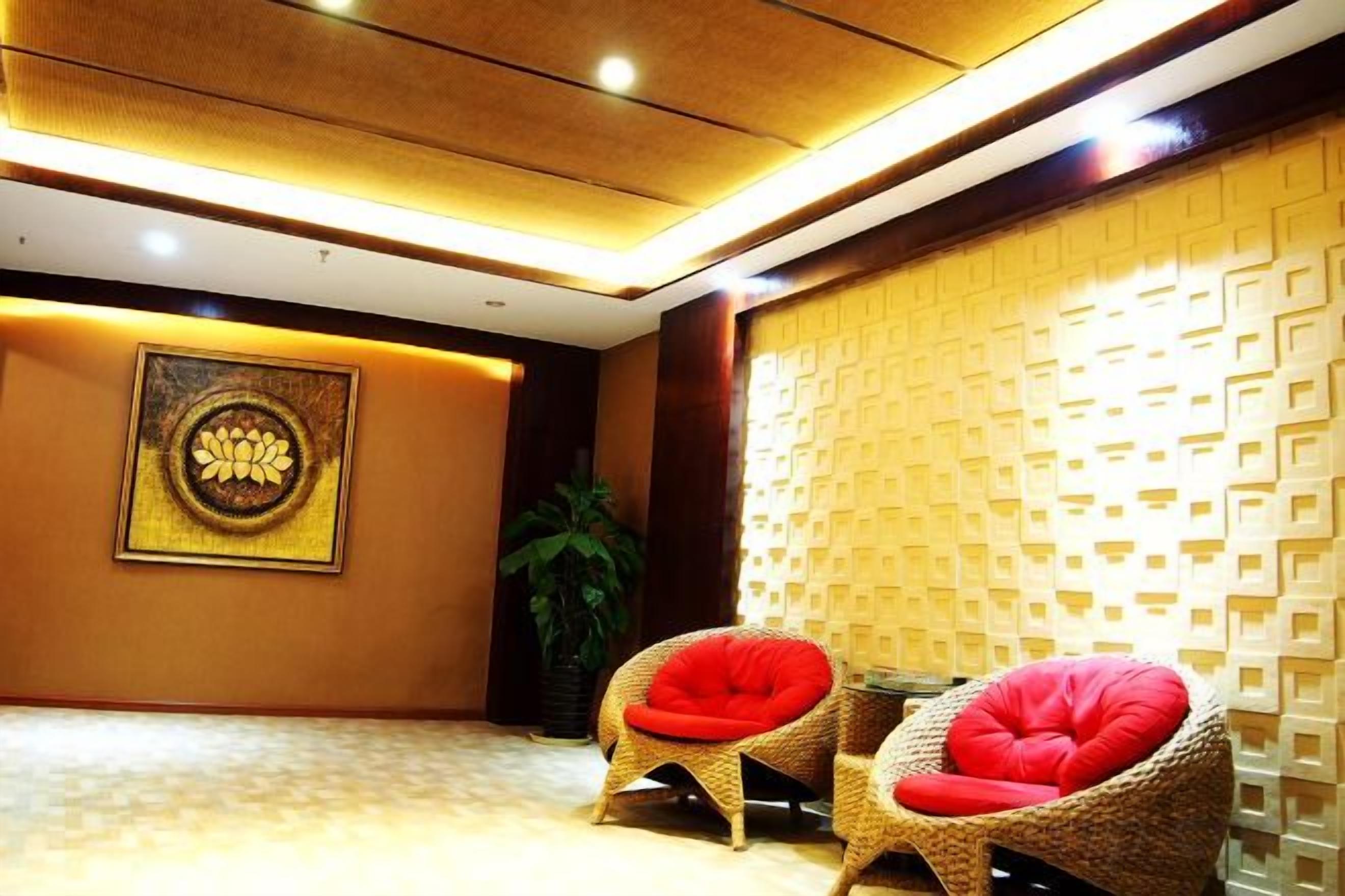 A lobby with two wicker chairs, a wall-mounted artwork, and a textured wall.