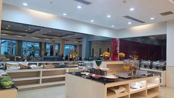 A modern hotel lobby with a reception desk, seating area, and a buffet counter.