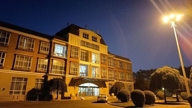 A multi-story hotel with a central entrance, large windows, and a well-lit facade. - Changchun Nanhu Hotel Qingyue Villa Holiday Apartment (Changchun)