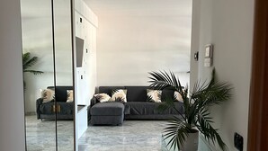 A modern living room with a sofa set, a glass coffee table, and a potted plant. - Rome Phoenix Suite cozy elegant, terrace and pool dream eur center (Roma)
