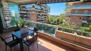 A balcony with a table and chairs, overlooking a residential area with multiple apartment buildings. - Rome Phoenix Suite cozy elegant, terrace and pool dream eur center (Roma)