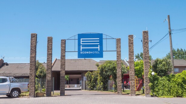 A hotel entrance with a prominent sign reading "ECONOHOTEL" and a stone archway. - Econohotel (Los Angeles)