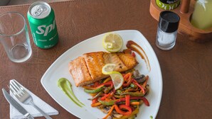 A plate of food with salmon, vegetables, and a lemon slice. - Econohotel (Los Angeles)