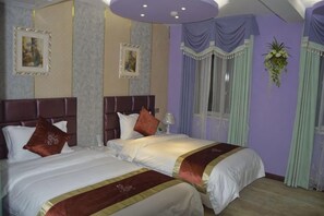 Habitación de hotel con dos camas, un ventanal grande y una planta decorativa.