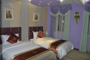 Habitación de hotel con dos camas, un ventanal grande y una planta decorativa.