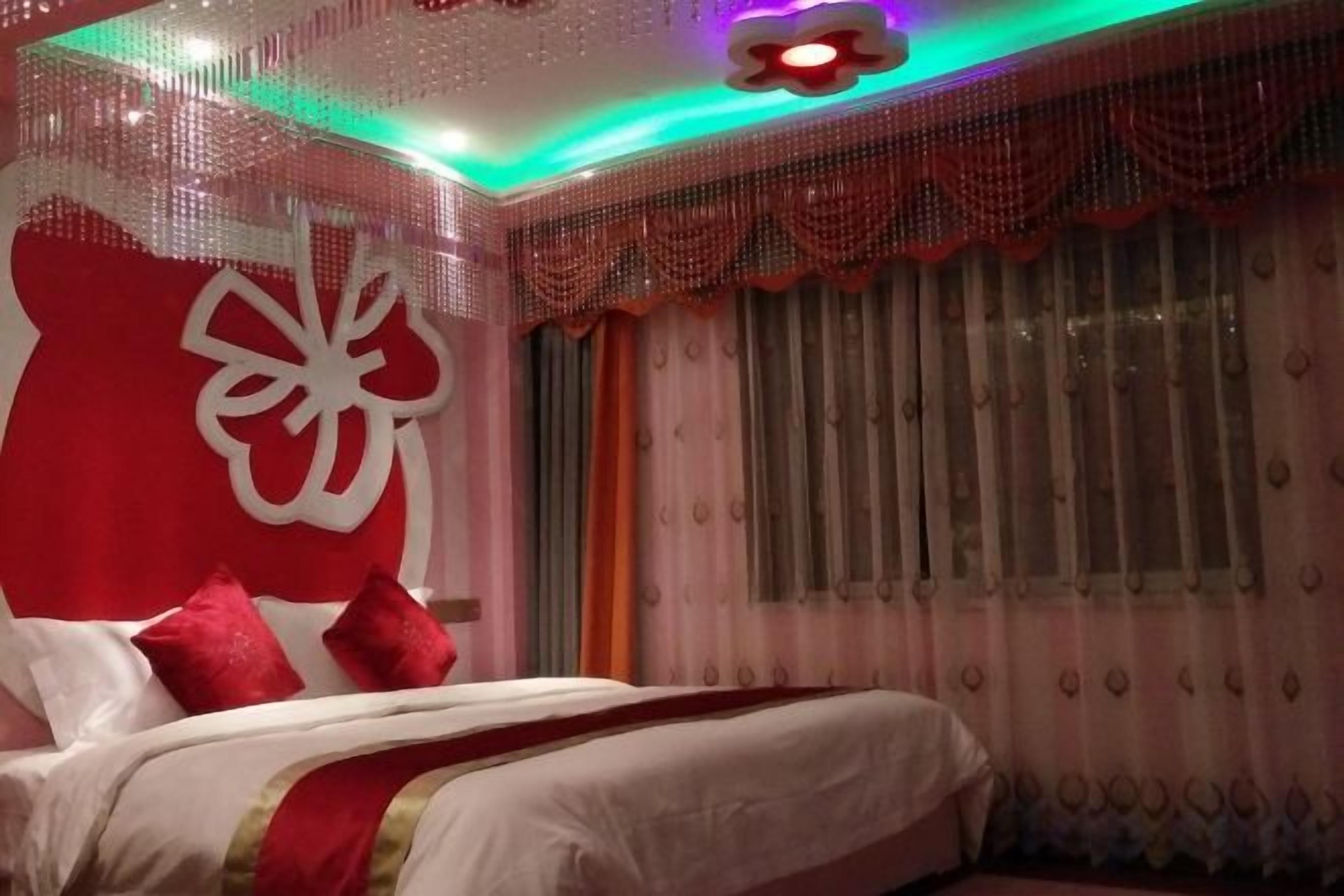 A bedroom with a bed, curtains, and a decorative wall.