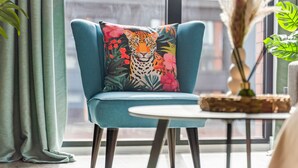 A teal armchair with a leopard print pillow, a small round table, and a vase with dried plants. - King Bed | 2bath | Parking | Netflix | City Centre (Birmingham)