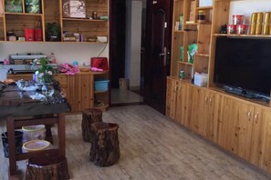 Una cocina con armarios de madera, una mesa de comedor y un televisor.